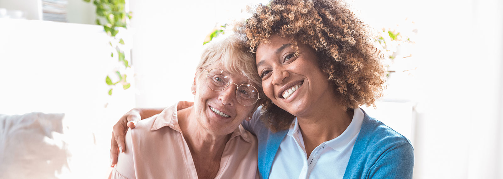 Senior woman and caregiver smiling and hugging