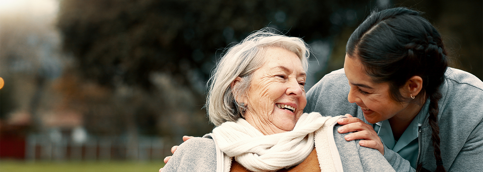 Senior woman with nurse in park.
